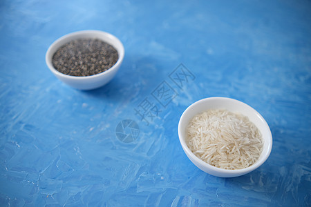 大米和奇亚籽是健康饮食的有机食品 在一个圆碗里 两个白色杯子 蓝色背景是用油画颜料画的麸质谷物乡村小麦营养农业薄片稀饭饮食荒野图片