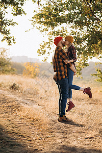 欢快的男男女女穿着漂亮的编织帽子散步蓝色幸福日落家庭橙子红色织物旅行树木温暖图片