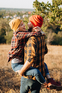 欢快的男男女女穿着漂亮的编织帽子散步女孩幸福家庭红色靴子牛仔裤地球橙子蓝色温暖图片
