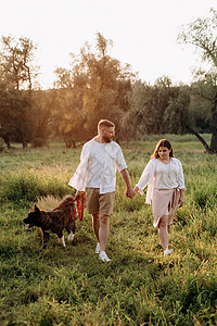 大狗跟一个男人和一个女孩散步棕色绿色男人活力朋友夫妻跑步打猎晴天树木图片