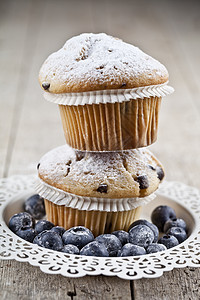 两只自制的新鲜松饼 上面有糖粉和蓝莓 白盘放在生锈木制桌子上面包甜点烹饪蛋糕糕点乡村早餐食物蓝色粉末图片