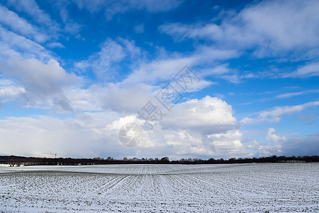 天空中美丽的云层在雪上望着覆盖农业的农田旅行草地阳光时间寒冷场景童话太阳国家蓝色图片