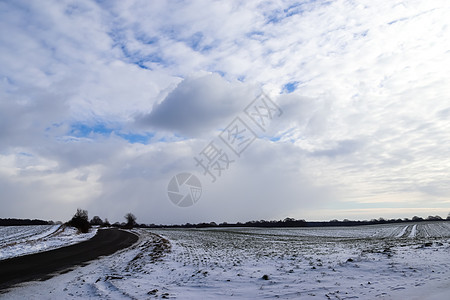 天空中美丽的云层在雪上望着覆盖农业的农田童话地平线风景阳光天气旅行蓝色时间森林牧场图片