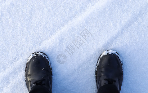 站在新雪中的黑色靴子的高角度视图男人皮革假期乐趣鞋类环境天气降雪男性季节图片