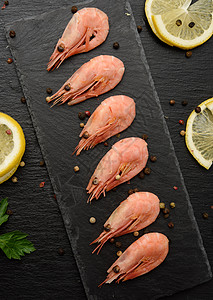 在黑板上排成一排的新鲜虾动物黑色桌子营养木板贝类胡椒烹饪饮食美食图片