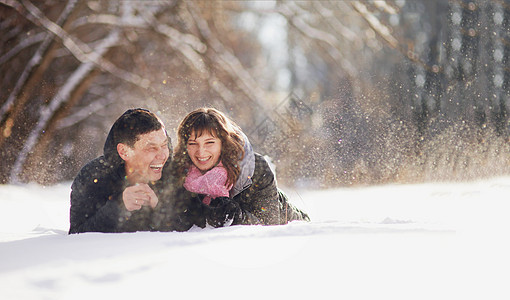 幸福的情侣躺在雪上笑着男人男性公园夫妻家庭森林假期女朋友女性友谊图片