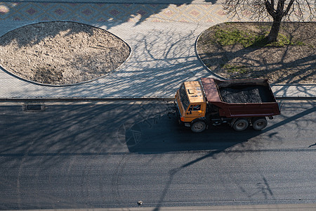 在道路建设工程期间 一辆卡车在城市的一条公路上开着破碎石搬运工劳动矿业石头工作瓦砾机械倾倒货物碎石图片