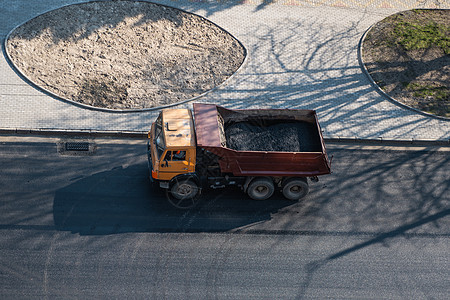 在道路建设工程期间 一辆卡车在城市的一条公路上开着破碎石萃取碎石倾倒车身搬运工反铲车辆劳动机械露天图片