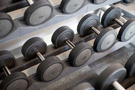 健身房的哑铃架训练男人架子黑色哑铃金属重量身体活动肌肉图片