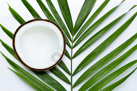 热带棕榈叶上的半椰子 在白色背景上异国芳香面包饮食糕点包子小吃水果休息疗法图片