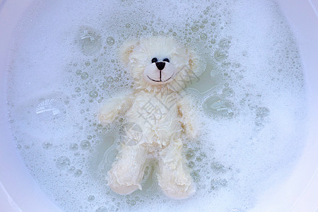 洗衣用洗衣洗涤的水在清洗前溶解时 将软玩具熊放在洗衣液中经济垫圈浴缸织物衣夹篮子工作粉末盆地身体图片