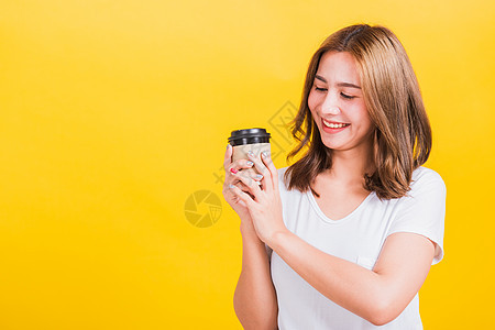 女人笑着抱着微笑 把咖啡纸杯拿掉塑料店铺杯子女孩黄色青少年白色工作室女性饮料图片