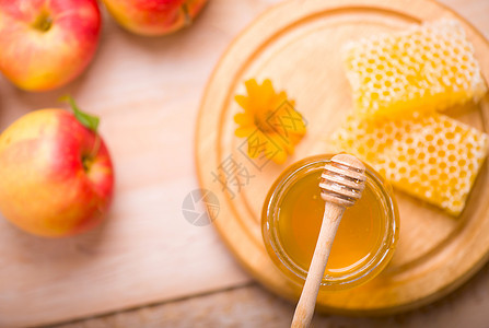 蜜蜂座背景的蜜糖 玻璃罐和蜂窝蜡中的蜜砖产品细雨甜点饮食蜜蜂流感毛毛养蜂业液体玻璃图片