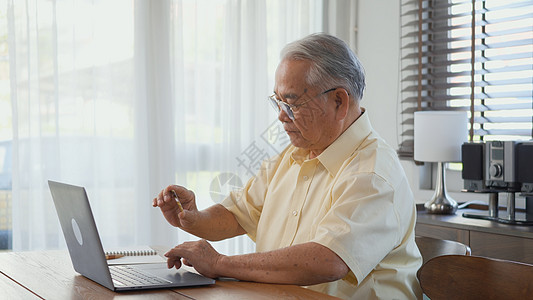 高级男子穿戴眼镜 坐在笔记本电脑工作椅上男人祖父工人技术成人花园互联网卡片老年网络图片
