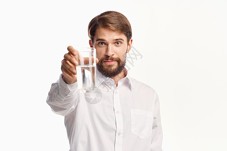 一杯清洁的水 用光衬衣在宽阔的风景下 放在男人手中饮食男性营养玻璃工作室白色饮料液体矿物手指图片