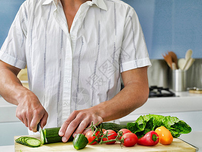 在家庭厨房用木板在木板上切蔬菜的年轻男子的中小区男人食用菌盘子切菜板食物砧板健康饮食黄瓜腹部柜台图片