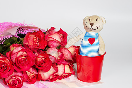 一束红玫瑰花 装在礼物纸包里 还有一只软玩具熊图片