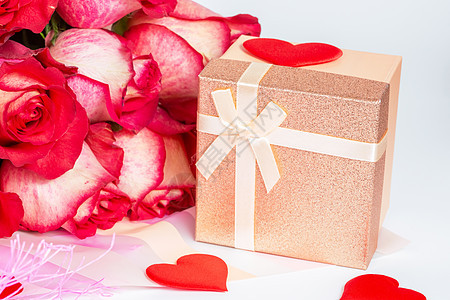 礼品纸包装中一束红玫瑰 一个带礼物的小盒子图片
