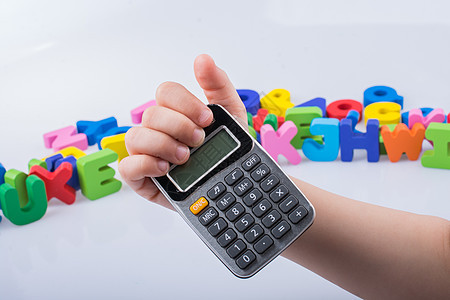 带多彩字母的小计算器在后面手边计算数学按钮会计游戏童年技术学习金融学校图片