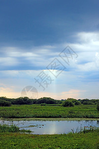 小湖和黑暗的天空 雨前农村气旋场景草原环境天气季风场地戏剧性草地图片