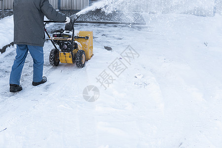 暴风雪过后 男子用造雪机清理车道 在街道上工作的除雪设备 从雪中清理街道 正在下雪行动投掷者男人工具车辆人行道机械鼓风机发动机风图片