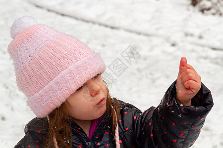 一个穿粉色帽子的女孩 在雪中玩摄影引擎盖手势针织帽幸福面料童年婴儿娱乐闲暇图片