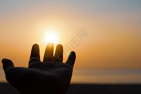 向日落的天空伸出双手 沙滩沙滩自然背景 放松和在假期中休息女士阴影女孩橙子自由精神财富海滩太阳手臂图片