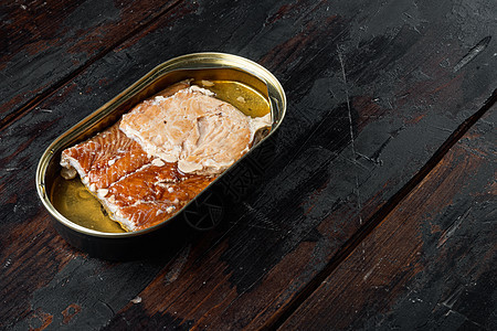 三文鱼 鱼罐头熏鱼罐头 装在锡罐里 在旧的深色木桌背景上 有复制空间和文本空间背景图片