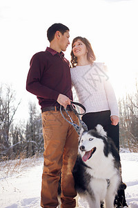 冬天在公园里 小夫妇和西比莉安哈斯基狗夫妻假期女性幸福男性友谊季节树木乐趣女孩图片