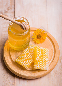 蜜蜂座背景的蜜糖 玻璃罐和蜂窝蜡中的蜜砖液体毛毛生物甜点药品美食养蜂业营养金子蜜蜂图片