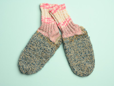 绿色背景的一对温暖舒适的编织袜子纺织品季节鞋类织物褐色手工配饰粉色羊毛衣服图片