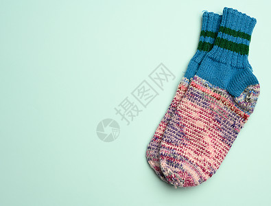 绿色背景的一对温暖舒适的编织袜子配饰手工鞋类羊毛蓝色季节衣服纺织品粉色织物图片