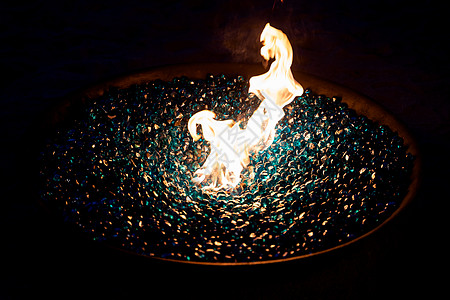 户外发光的蓝色玻璃石 用火焰特写户外壁炉图片