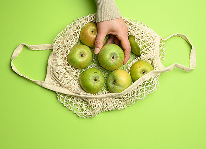 绿色背景 可再使用物品概念的绿苹果蓝色面纸袋Beige纺织品袋回收浪费水果购物市场生态纺织品收成棉布营养图片
