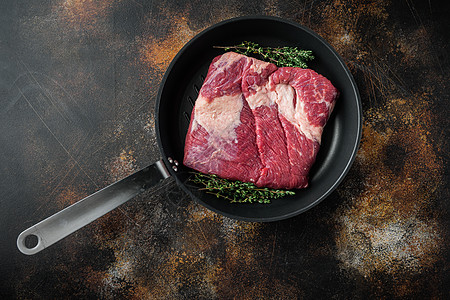 Raw brisket 牛肉brisfet 肉 用旧的深黑生锈背景 顶视平面 有文本复制空间图片