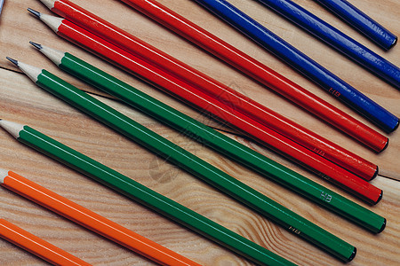 工作桌上的多色铅笔 木制背景办公室缝合器活页夹学校商业木板职场技术玻璃键盘写作桌面图片