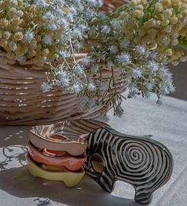 一套大象形状的陶瓷杯和编织篮子里的花束 把房子装饰得很漂亮图片