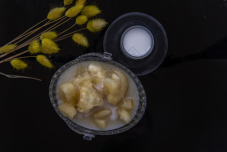 糖浆中的木薯通常在黑地板上配有椰子牛奶 泰国的传统甜点干花午餐饮食营养盘子勺子面粉小吃食物桌子图片