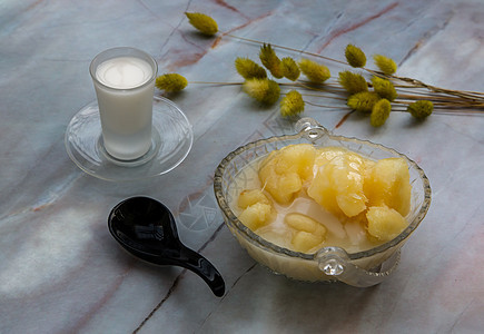 糖浆中的木薯通常配有大理石桌上的椰子牛奶 泰国的传统甜点桌子勺子烹饪玻璃小吃营养美食土豆午餐盘子图片