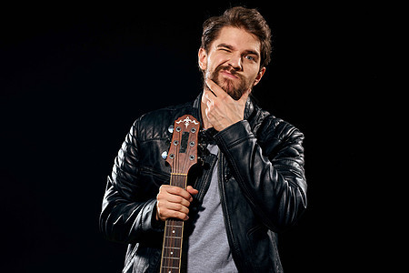 一个手拿着吉他的男人 皮衣夹克音乐表演 摇滚明星摇滚明星现代风格的黑暗背景艺术艺术家乐器歌手吉他手岩石玩家音乐会金属歌曲图片