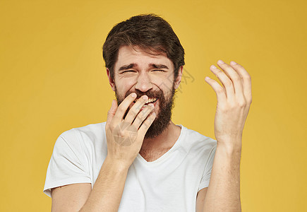 近身肖像男子 棕发胡子白T恤黄色背景图片