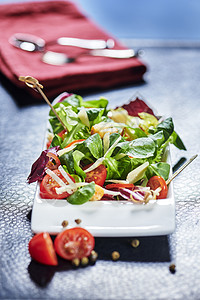 新鲜混合沙拉 在黑盘餐桌上加端面番茄和樱桃西红柿 倒橄榄油图片
