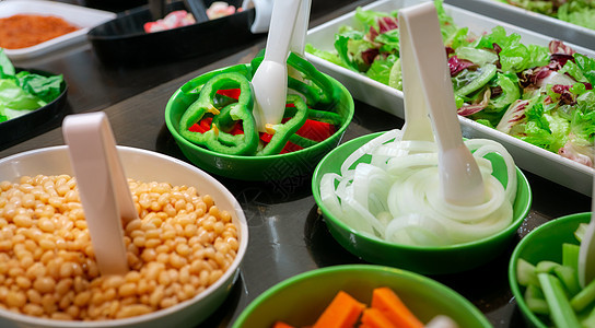 餐厅的沙拉吧自助餐 午餐或晚餐供应新鲜沙拉吧自助餐 健康食品 绿色和红色辣椒和洋葱在柜台上的绿色碗里 餐饮食品 宴会服务 素食图片