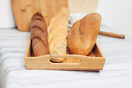 餐桌上的面包篮上的新鲜面包 早餐饭种子面粉大麦糕点美食厨房包子桌子谷物食物图片