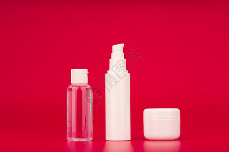 红色背景的皮肤护理产品 食用 面霜和眼膏下套 美容化妆品的概念图片