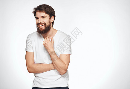 穿着白色T恤衫的情感男人 在轻背景情调上 模仿一个学生的景色乐趣休闲装成人灰色微笑手指幸福商务快乐手势图片
