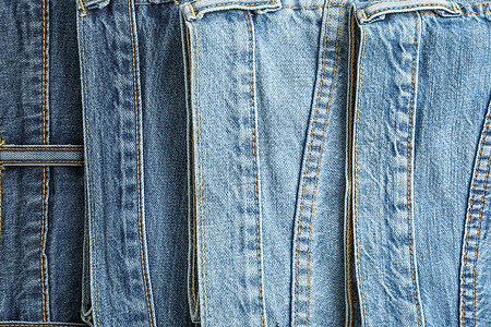 不同颜色的牛仔裤作为 tex 的背景空间蓝色棉布材料桌子牛仔布折叠织物黑色口袋裤子图片