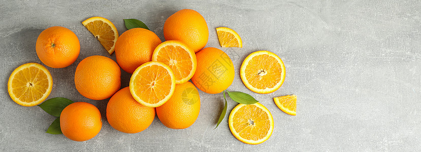 许多熟熟橙子 灰色桌上有叶子派对热带蓝色作品排毒树叶水果食物饮食橘子图片