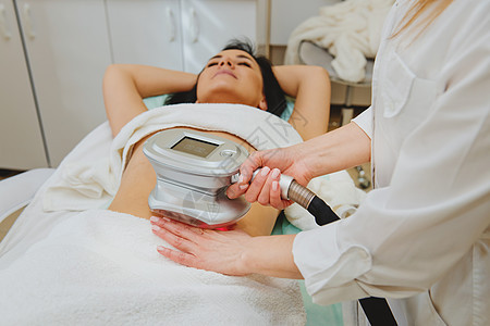 美容师在女性肚子上做按摩 用特殊仪器按摩图片