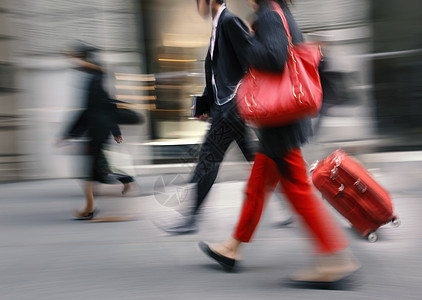 带着红色包和手提箱走在街上的人速度压力男人行人人行道团体人士商务购物街道图片
